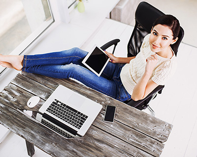 Mujer en su escritorio con una laptop y una tableta